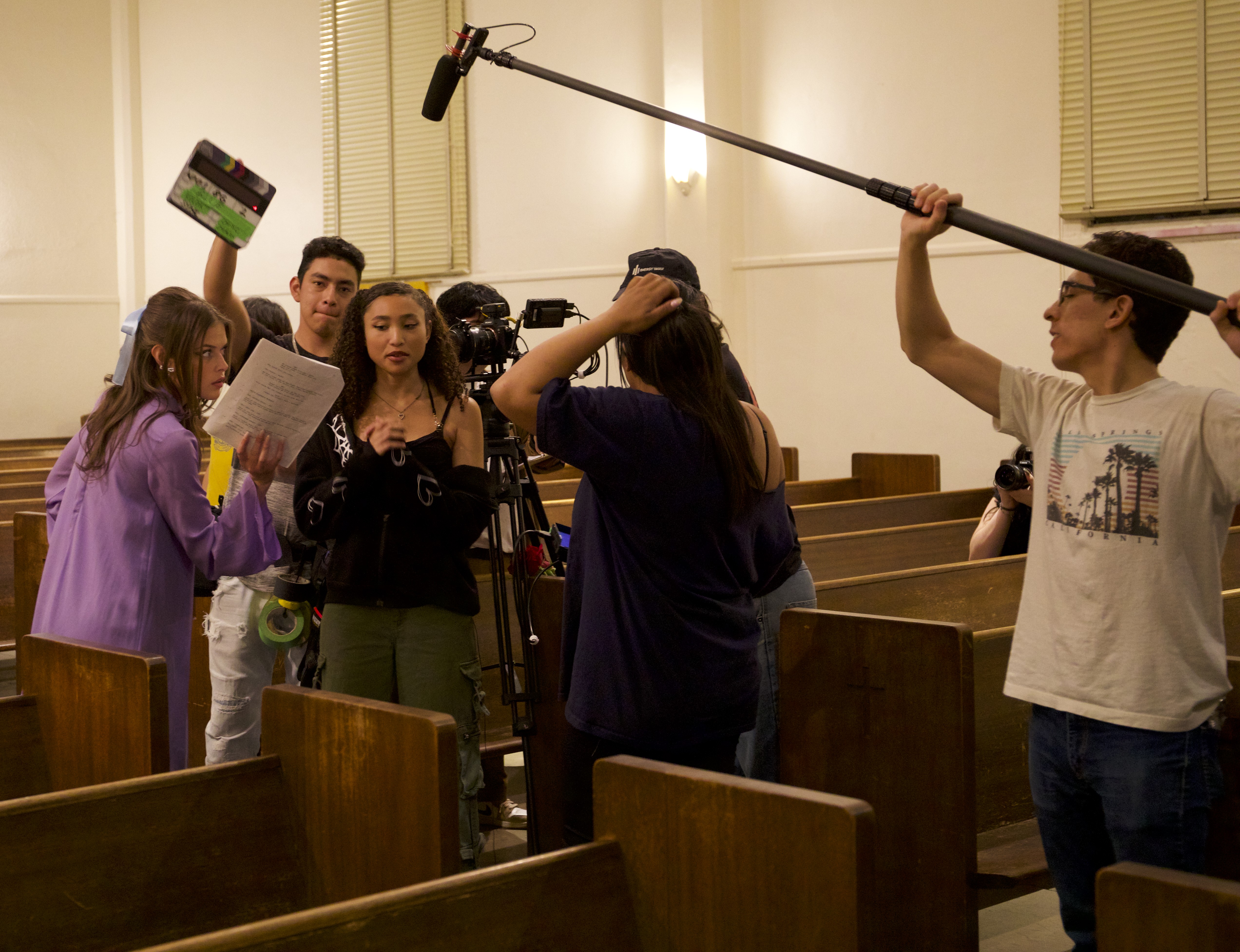 Students filming with a boom microphone and camera on tripod