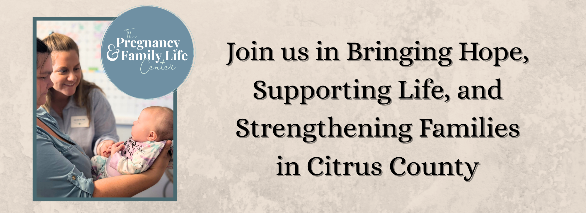 client holding baby with executive director stnading by smiling