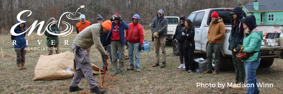 Stewardship Manager Indigo Roper-Edwards demonstrates how to plant a tree to a group of volunteers. Photo by Madison Winn